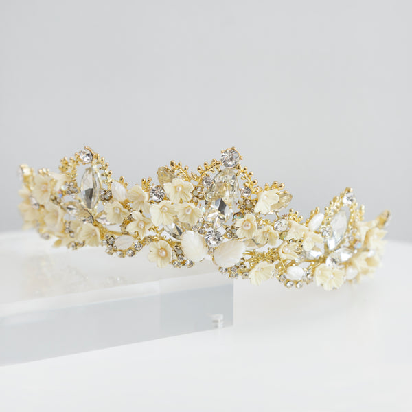 Espectacular corona metálica con cristales de tipo swarovski, decorada con flores de porcelana y hojas -madre perla-